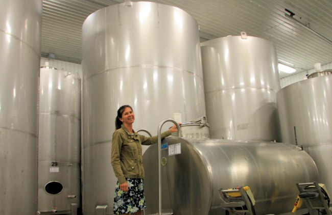 Catherine Langlois with her first wine tank anud a forest of massive steel tanks
